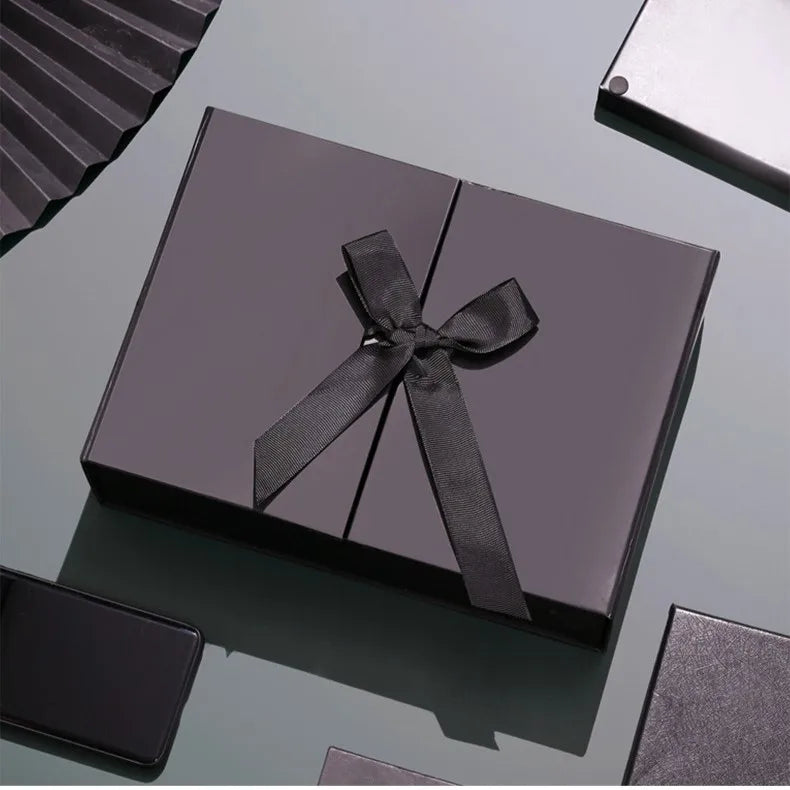 Caixa dobrável com fechamento magnético e laço decorativo.