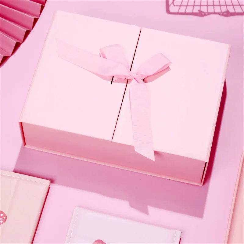 Caixa dobrável com fechamento magnético e laço decorativo.